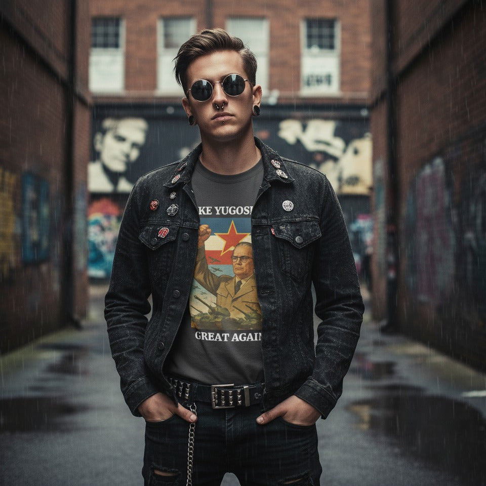 Man wearing a denim jacket and graphic t-shirt in an alley with graffiti.